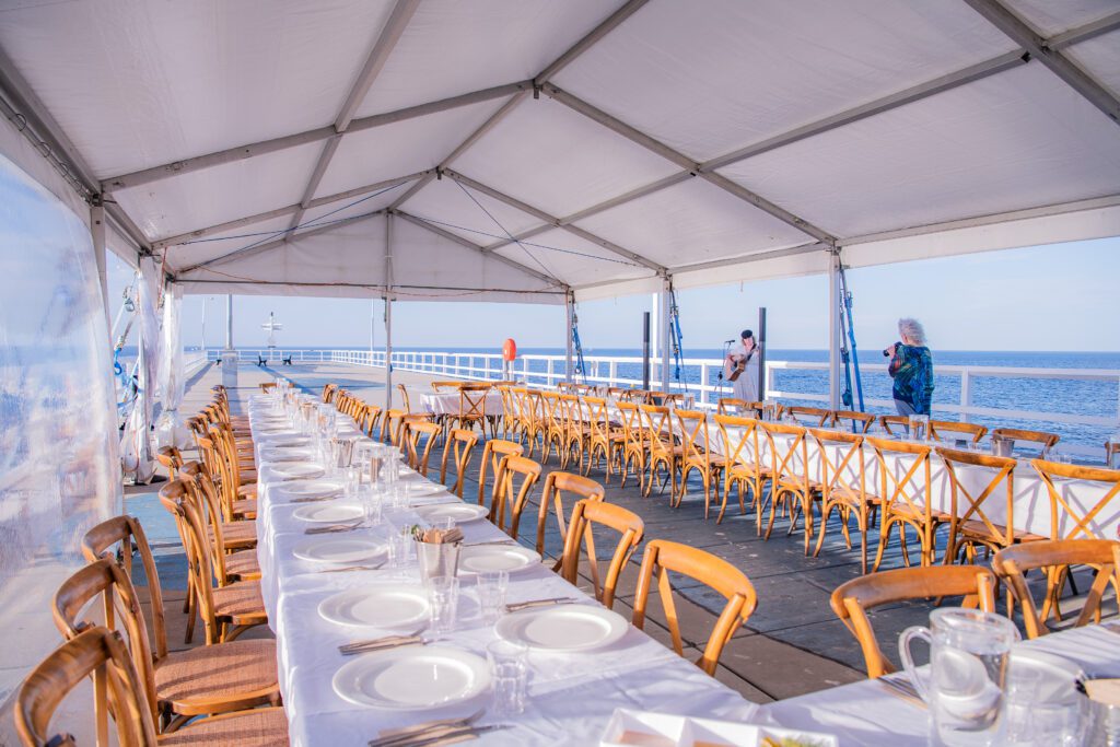 Long table dinner setup for our Sea & Stars event at the end of the jetty inside the pop-up Marquee